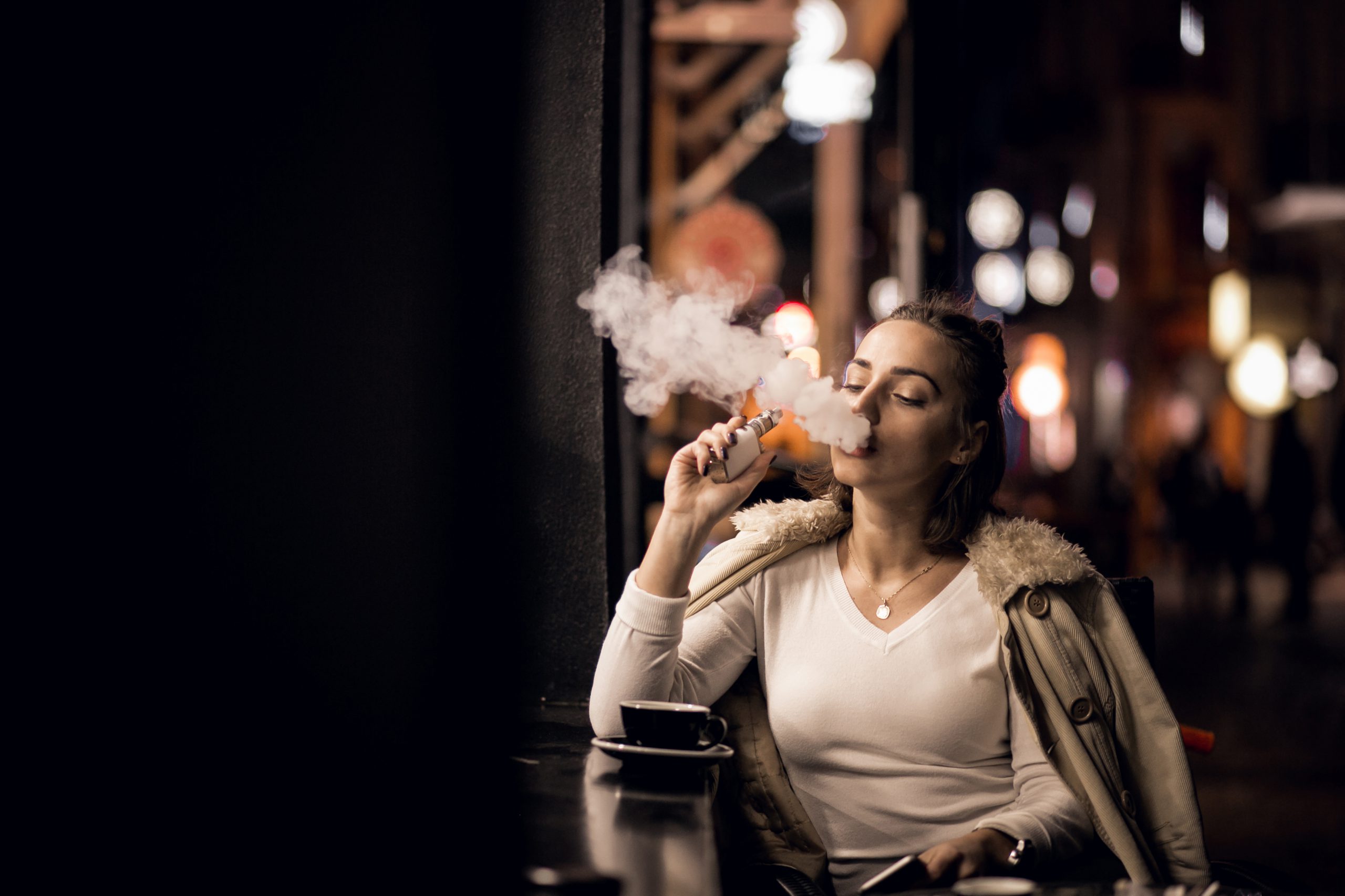 Moça fumando cigarro eletrônico (vaping)